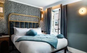 a bedroom with a bed with blue pillows on it at Hôtel BOHEM, Sacré-Cœur in Paris +24 photos