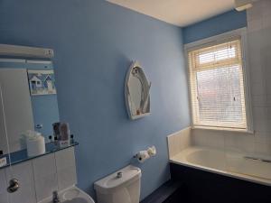 a bathroom with a toilet and a tub and a sink at The Elmer in Yapton