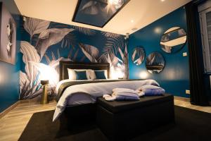 a bedroom with a large bed with blue walls at GITE L'ECRIN Pays de Caux in Bosc Renoult