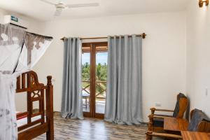 a bedroom with a bed and a window at Jabali Bungalows Lodge in Paje
