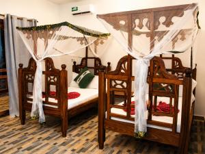 a bedroom with two bunk beds and two chairs at Jabali Bungalows Lodge in Paje +111 photos