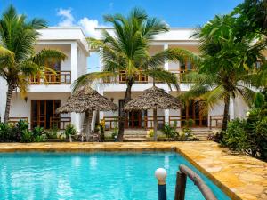 a resort with a swimming pool and palm trees at Jabali Bungalows Lodge in Paje