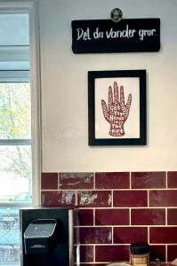 a picture of a hand hanging on a wall at Autentisk Gård Tæt På Vandet På Samsø in Ballen