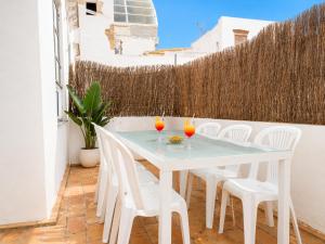 a white table and chairs on a balcony with drinks on it at Apartamentos Larga 70 in El Puerto de Santa María