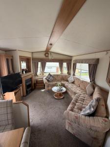 a living room with a couch and a table at Jemmas Holiday Home in Arbroath