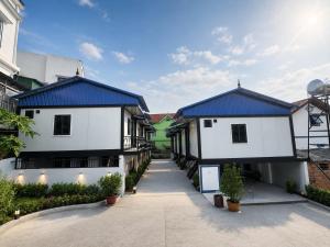 a row of white buildings with blue roofs at ILLUMI Homestay in Dong Hoi