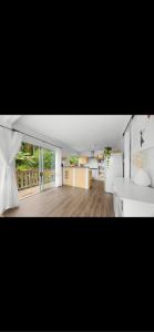 a large room with a kitchen and a living room at Sunbird House Piha in Piha