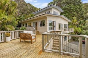 a home with a deck with a house at Sunbird House Piha in Piha
