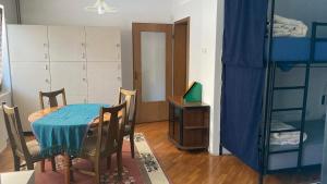 a room with a table and chairs and a bunk bed at Kardelen Hostel in Prishtinë