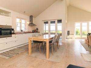 a kitchen and dining room with a wooden table and chairs at 5 star holiday home in Nysted in Nysted +32 photos