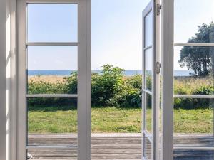 an open window looking out at the ocean at 5 star holiday home in Nysted in Nysted