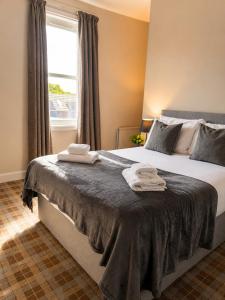 a bedroom with a large bed with towels on it at The Anglers Inn in Guildtown