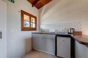 a kitchen with a counter and a sink and a window at Stay Easy Sidari Apartments in Sidari