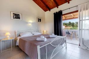 a bedroom with a bed with two towels on it at Stay Easy Sidari Apartments in Sidari