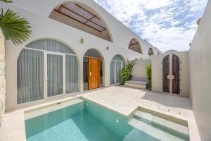 a house with a swimming pool in the backyard at 2BR Pool Villa Bingin w Ocean View Rooftop - Tasanaa in Badung