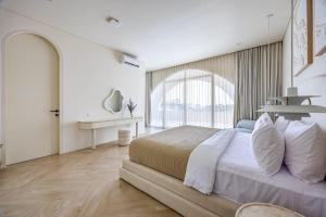 a white bedroom with a large bed and a desk at 2BR Pool Villa Bingin w Ocean View Rooftop - Tasanaa in Badung +33 photos