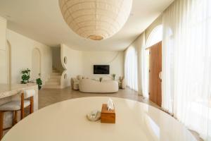 a living room with a white table and a couch at 2BR Pool Villa Bingin w Ocean View Rooftop - Tasanaa in Badung