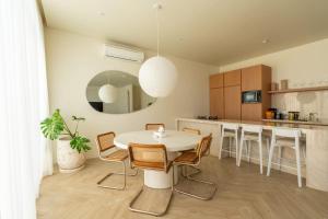 a kitchen and dining room with a white table and chairs at 2BR Pool Villa Bingin w Ocean View Rooftop - Tasanaa in Badung