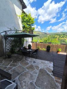 a patio with a table and chairs and an umbrella at Tsarevets Residence in Veliko Tŭrnovo