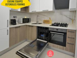a small kitchen with a stove and a sink at L'escapade in Sousse
