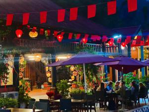 a group of people sitting at tables under umbrellas at Cat Ba SOL Beach in Cat Ba