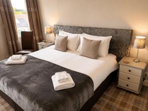 a bedroom with a large bed with towels on it at The Anglers Inn in Guildtown