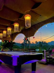 a pool table in front of a building with chandeliers at Cat Ba SOL Beach in Cat Ba