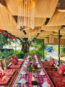 a long long table with red and red pillows on it at Cat Ba SOL Beach in Cat Ba