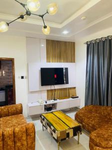 a living room with a couch and a flat screen tv at Double Homes in Agege