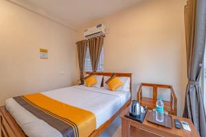 a bedroom with a bed with orange and white sheets at Itsy Hotels Snowdrop in Coimbatore +28 photos