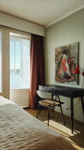 a bedroom with a desk and a picture of a bird at Villa Astrid in Pietarsaari