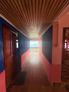 a hallway of a building with a wooden ceiling at Pemazang Homestay in Sombāri