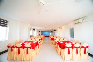 a room with rows of chairs with red and yellow tablecloths at SAMMY Hotel - Khách sạn SAMMY in Giáp Vinh Yên