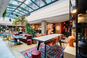 a restaurant with tables and chairs and a glass ceiling at Canopy By Hilton Paris Eiffel Tower in Paris