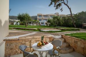a table and chairs with a bowl of fruit on it at Parthenis Hotel & Suites in Malia