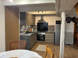 a kitchen with stainless steel appliances and a table at Gîte Therence chez Bruno in Sainte-Thérence +13 photos