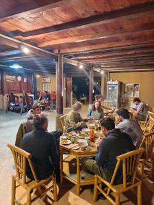 a group of people sitting at a table eating at Nùng An homestay-Nùng ethnic group in Bà Dương