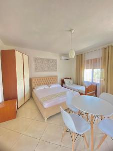 a bedroom with a bed and a table and chairs at APARTAMENT RADHIME in Vlorë