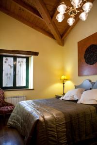 a bedroom with a bed and a window and a chandelier at Casa Rural La Majada de Peñacorada in Fuentes de Peñacorada