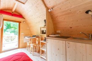 a kitchen and dining room of a log cabin at Hébergements Insolites Camping la Pinède des Mées in Les Mées