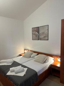 una camera da letto con un letto su cui sono appoggiati due asciugamani di Apartmani Samec a Novalja (Novaglia)