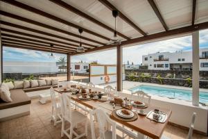a dining room with a table and chairs and a pool at Villa Barrilla by Villalize in Tinajo