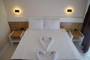 ein Schlafzimmer mit einem Bett, auf dem zwei Herzen abgebildet sind in der Unterkunft Uraz Hotel in Kemer