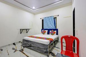 a bedroom with a bed and a red chair at FabHotel Mahi Resort in Aurangabad +22 photos