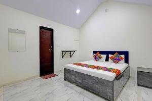 a bedroom with a bed in a white room at FabHotel Mahi Resort in Aurangabad