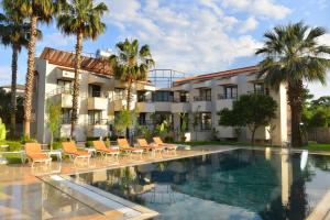 ein Hotel mit Swimmingpool und Palmen in der Unterkunft Uraz Hotel in Kemer