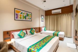 a hotel room with two beds in a room at Treebo Hub in Indore +36 photos