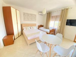 a bedroom with a bed and a table and chairs at APARTAMENT RADHIME in Vlorë