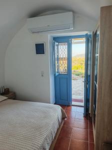 a bedroom with a bed and a blue door at Kastri 2 in Kythira +13 photos
