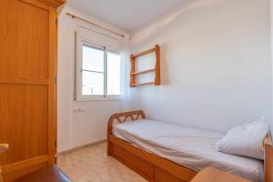 a small bedroom with a bed and a window at ELS BALADRES in Deltebre